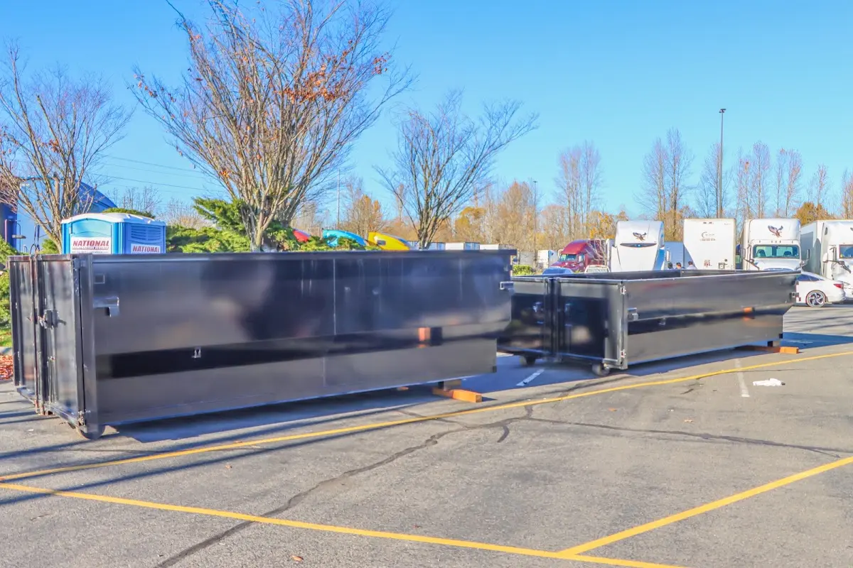 Professional dumpster rental service with roll-off container on residential driveway in University